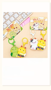Close-up of cute cartoon turtle, bee, and cow charms on colorful backpack keychains
