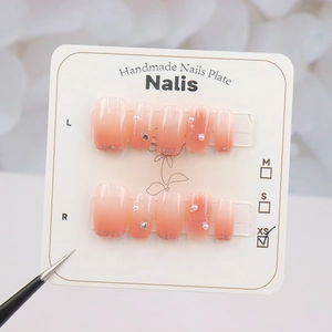 Faux ongles faits main dégradé pêche avec perles, strass et paillettes pour femmes