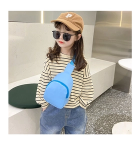 Sky blue PU leather toddler crossbody bag with zipper and adjustable strap on a model