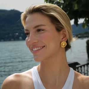 Woman wearing 18k gold plated stainless steel hoop earrings with woven texture detail