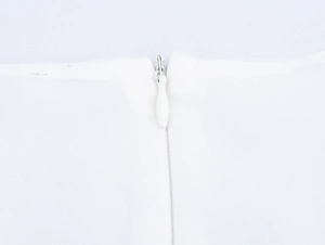 Détail d'une fermeture éclair invisible sur une robe en tulle blanc avec couture soignée