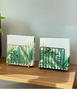 Detailoverzicht van verticale ijzeren servethouders in goud en zwart met roosterdesign