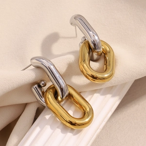 Detail of 18K gold and silver hollow chain link earrings on a white elegant column