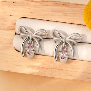 Silver bow earrings with pink square zircon drop pendants displayed in a wooden box