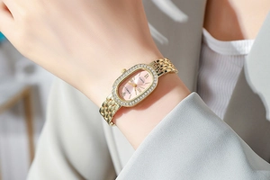 Gros plan d'une élégante montre à quartz ovale en or avec lunette en diamants