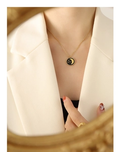 Detail of vintage celestial necklace with moon and star pendant on a gold chain