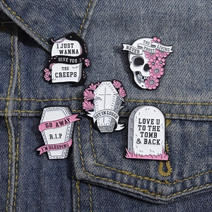 Gothic pink flower skull and tombstone enamel pin set on blue denim jacket