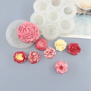 Detailed view of silicone molds with finished rose and carnation flower decorations