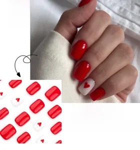Detail view of short square press-on nails in glossy red with white heart patterns