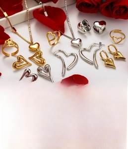 Detail of gold and silver titanium steel heart jewelry set with zircon stones