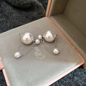 Detail of silver pearl drop earrings with double pearls and elegant delicate chain