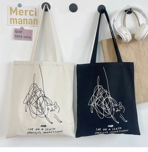 Detail showing the cat doodle design and text print on canvas tote bags