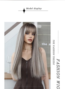 Long straight ash blonde ombre wig with bangs shown on a fashion model in a stylish indoor setting