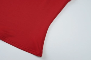 Detailed close-up of the red knitted fabric and side waist stitching on the two-piece set