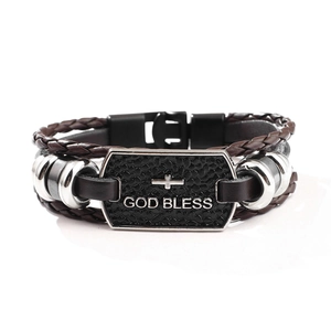 Detail of brown braided leather bracelet with God Bless engraved on metal plate