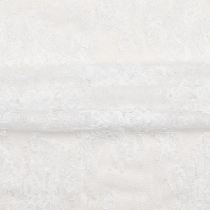 Close-up detail of white lace fabric featuring elegant floral embroidery and mesh texture