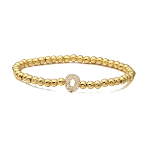 Detailed top view of golden beaded bracelet with micro-pave zircon letter O pendant