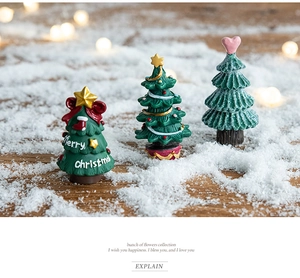 Detailed macro of resin Christmas tree miniatures with Merry Christmas text on snow