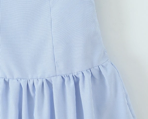 Detailed view of blue and white vertical stripe fabric with elegant pleated design