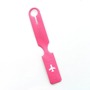 Pink silicone luggage tag detail featuring Happy Flight logo and airplane icon