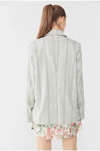 Back view of a plaid blazer jacket in light colors styled with a floral print skirt