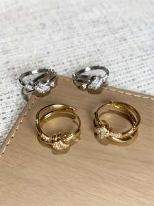 Detailed view of gold and silver knotted hoop earrings with sparkling pave zircon stones