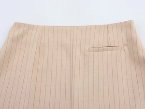 Gros plan détaillé du tissu beige à rayures avec une poche passepoilée et coutures fines