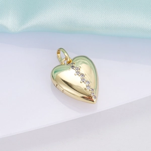 Detail of 18K gold heart pendant with crystal line inlay on elegant blue silk