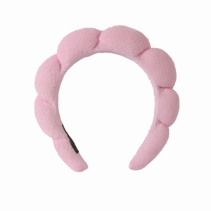 Detailed view of pink towel fabric headband with thick padded twist texture for skincare