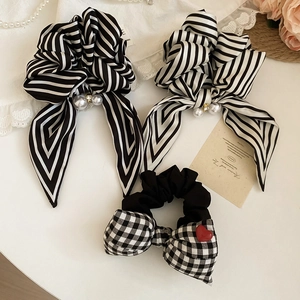 Detail of striped bow hair scrunchies with pearls and checkered pattern accents