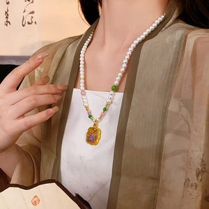 Detail of beaded pearl necklace with gold lotus pendant and traditional enamel craftsmanship