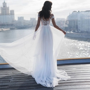 Elegant sleeveless white lace wedding dress with back embroidery and long train design