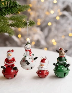 Close-up of four festive Christmas metal bells with Santa, snowman and elk characters