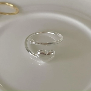 Minimalist 925 sterling silver open heart ring displayed on a white ceramic tray