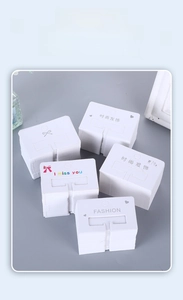 Detail of white paper hair claw display cards with minimalist fashion prints and patterns
