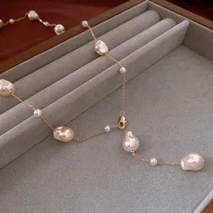 Baroque irregular pearl necklace with gold-plated chain on a luxury velvet display tray