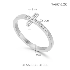 Bague en acier inoxydable poli avec détail de croix en zircon argenté sur fond blanc