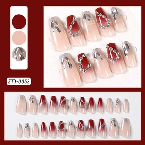 Macro shot of 24pcs long coffin press-on nails with red gradient and luxury rhinestones