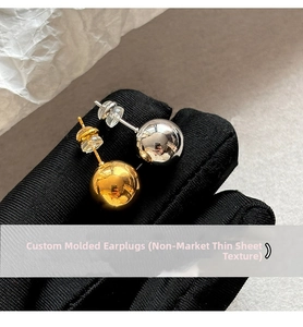 Detailed macro view of gold and silver sphere stud earrings with high-polish finish