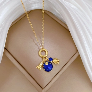 Macro shot of space-themed charms with crystal rocket and astronaut on a gold chain