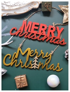 Close-up of wooden Merry Christmas hanging ornaments with red and gold glitter finish