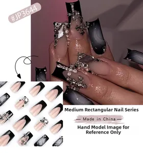Detail of black French press-on nails with silver 3D crosses and pearl embellishments