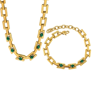 Detail of 18K gold plated necklace and bracelet set featuring green square cut gems