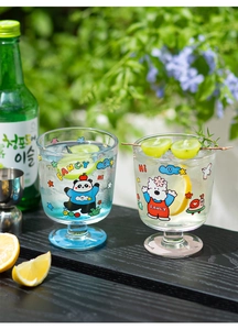 Gros plan de jolis gobelets en verre avec motifs de panda et de chien sur une table de jardin