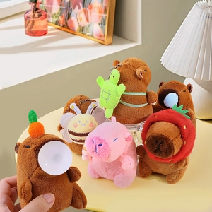 Plush Capybara keychains in various costumes like strawberry and bee on a table