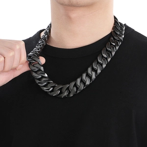 Close-up of 24mm black stainless steel Cuban link chain necklace worn by a male model