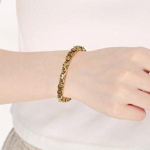 Detail of a 18K gold plated stainless steel Byzantine chain bracelet on a model wrist