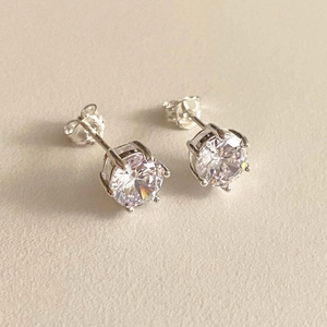 Detail of 925 sterling silver stamp on classic four-prong round zircon stud earrings
