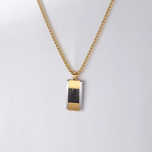 Détail d'un pendentif rectangulaire avec carbone noir sur une chaîne à maillons dorés