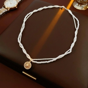 Double-layered gold-plated pearl necklace with shimmering star compass pendant
